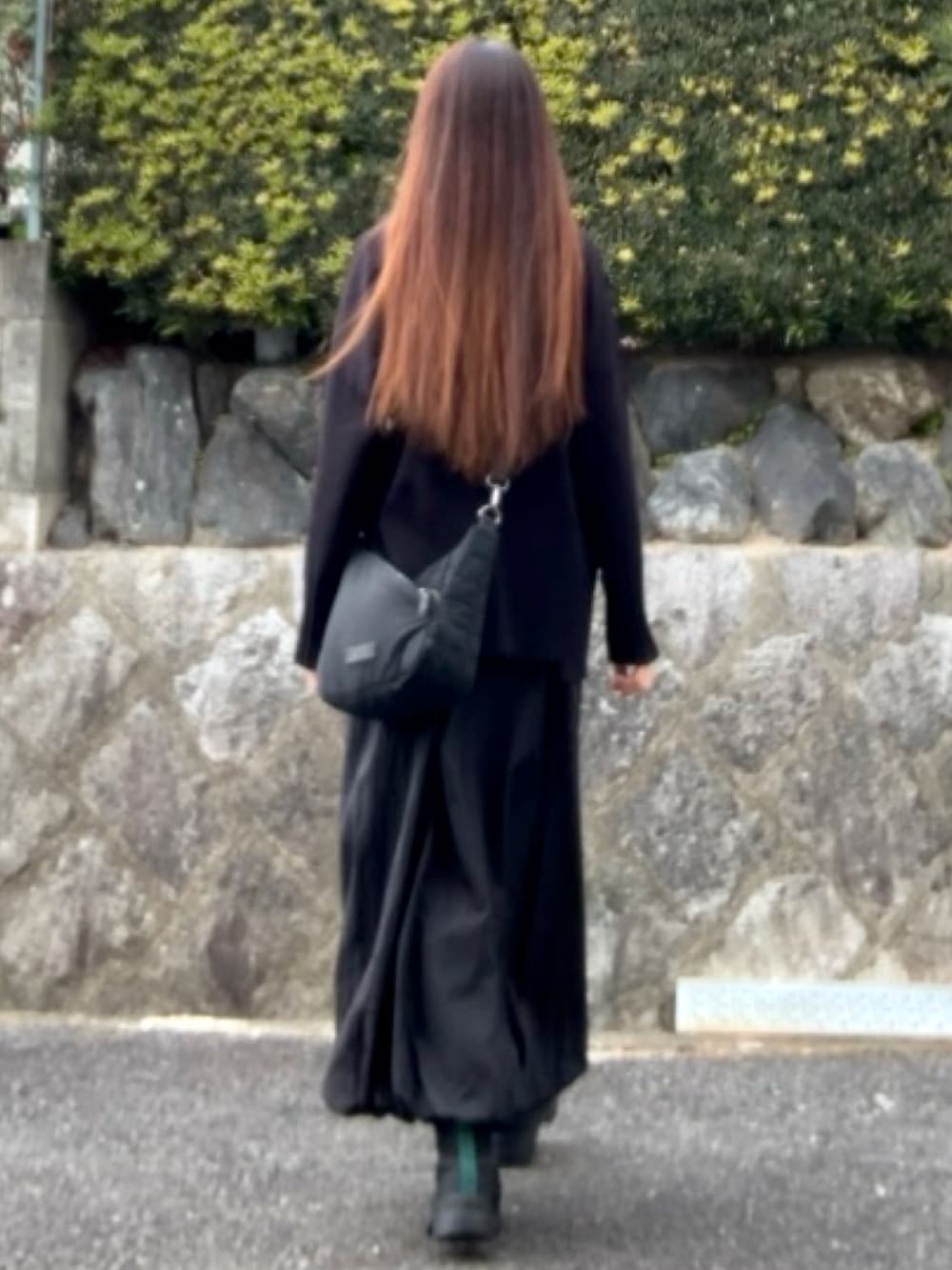 ブラック系のバッグ、ブラック系のニット/セーター、ブラック系のスカートを着用したレディースの冬コーディネートの2枚目の写真