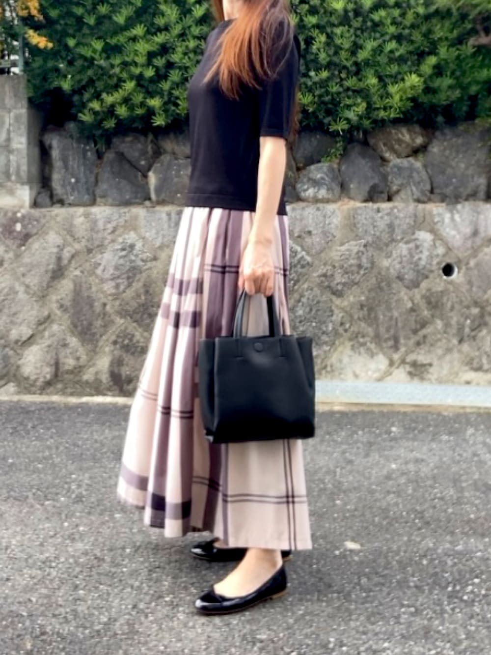 ブラック系のニット/セーター、ベージュ系のスカート、ブラック系のトートバッグを着用したレディースの秋コーディネートの2枚目の写真