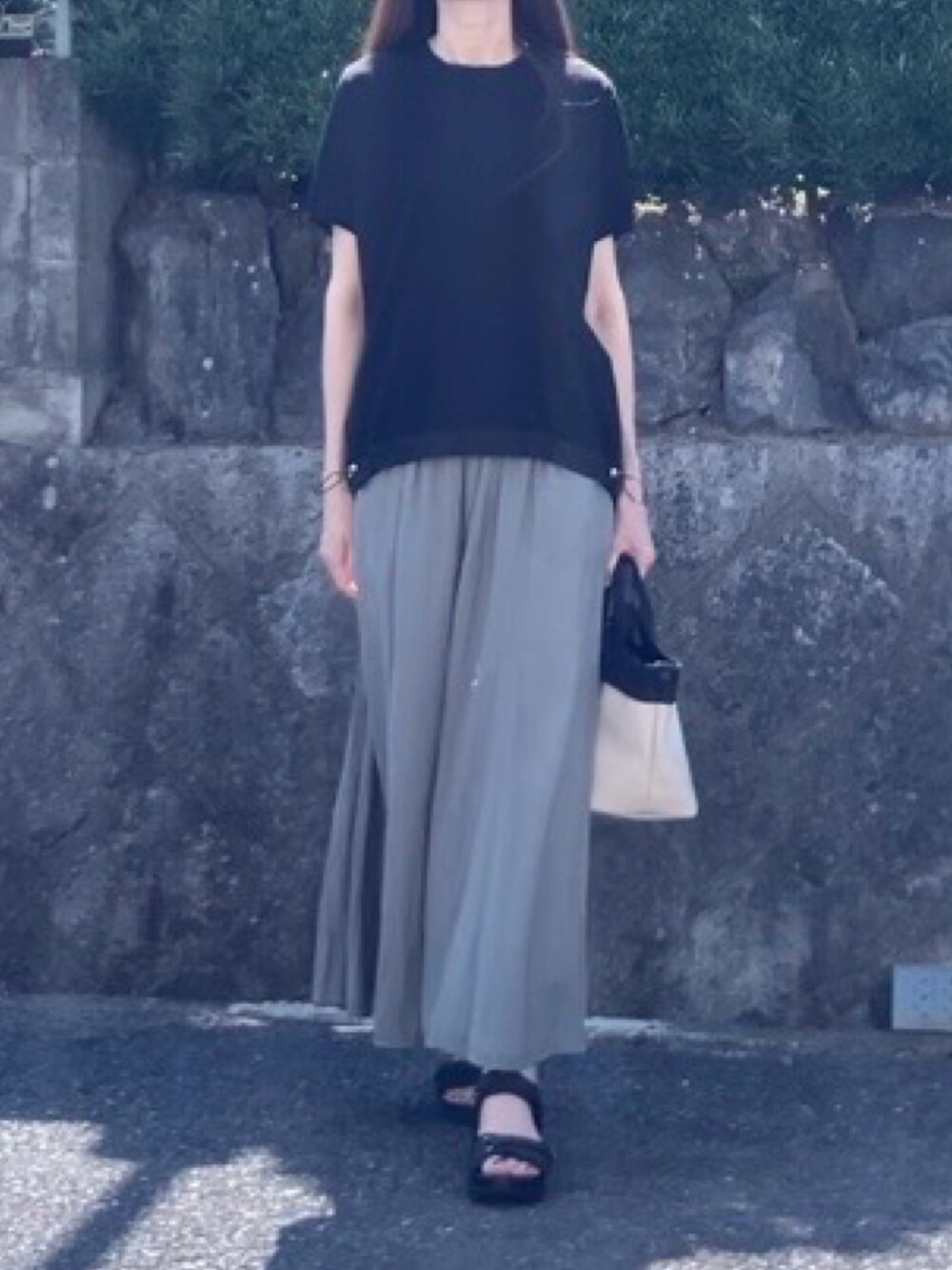 グリーン系のその他パンツ、ホワイト系のトートバッグ、ブラック系のTシャツ/カットソーを着用したレディースの夏コーディネートの2枚目の写真