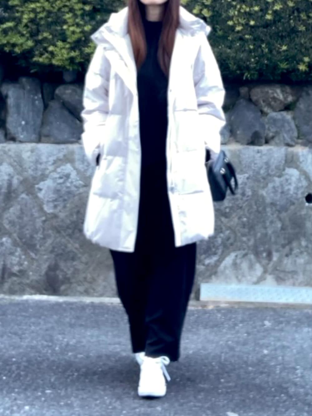 ベージュ系のダウンジャケット/コート、ブラック系のニット/セーター、ブラック系のスカートを着用したレディースの冬コーディネートの3枚目の写真