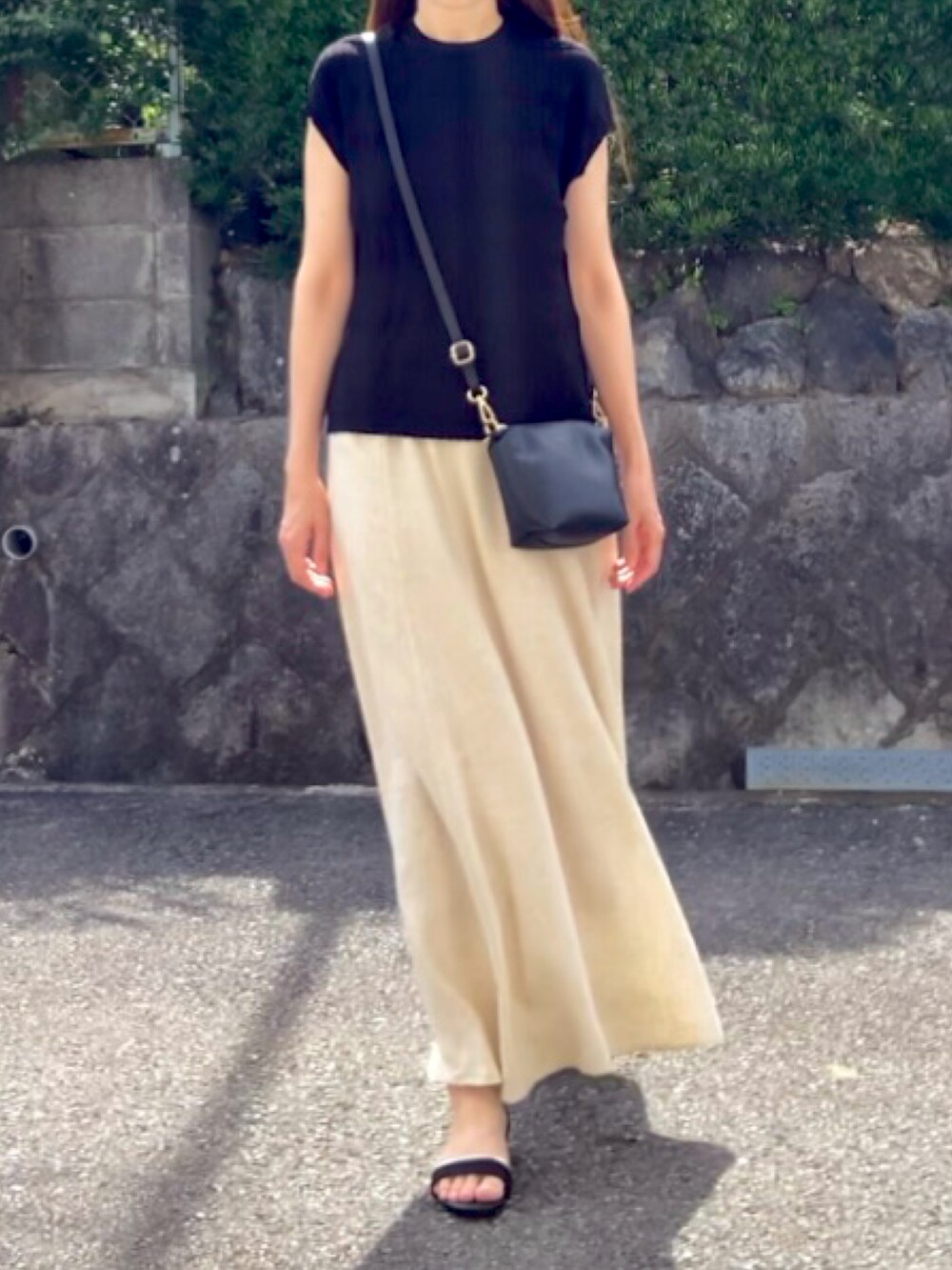 ブラック系のTシャツ/カットソー、ベージュ系のスカート、ブラック系のサンダルを着用したレディースの夏コーディネートの3枚目の写真