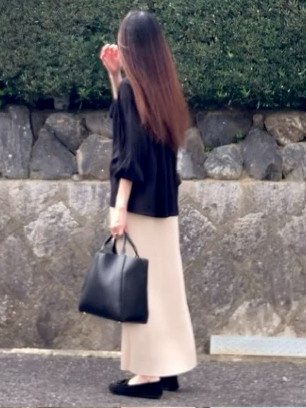 ブラック系のシャツ/ブラウス、ブラック系のニット/セーター、ホワイト系のスカートを着用したレディースの秋コーディネートの2枚目の写真