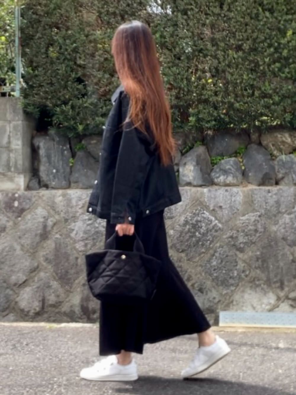 ブラック系のデニムジャケット、ブラック系のスカート、ブラック系のバッグを着用したレディースの春コーディネートの2枚目の写真