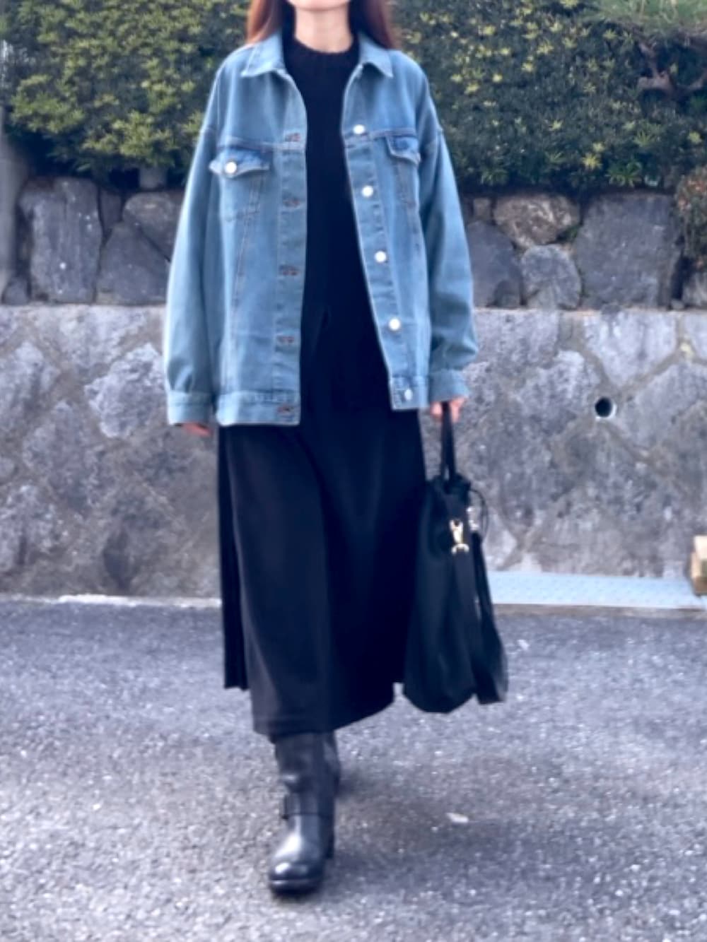 ブルー系のデニムジャケット、ブラック系のトートバッグ、ブラック系のスカートを着用したレディースの冬コーディネートの3枚目の写真