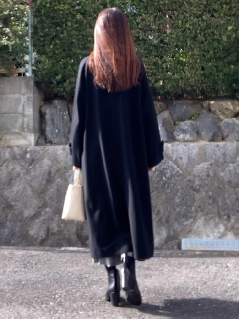 ブラック系のその他アウター、グレー系のスカート、ブラック系のブーツを着用したレディースの冬コーディネートの3枚目の写真