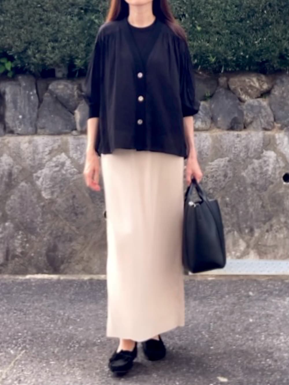 ブラック系のシャツ/ブラウス、ブラック系のニット/セーター、ホワイト系のスカートを着用したレディースの秋コーディネートの4枚目の写真