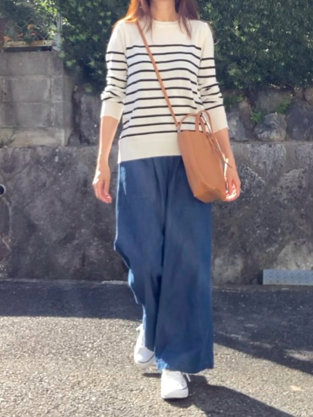 イエロー系のトートバッグ、ホワイト系のスニーカーを着用したレディースの秋コーディネートの3枚目の写真