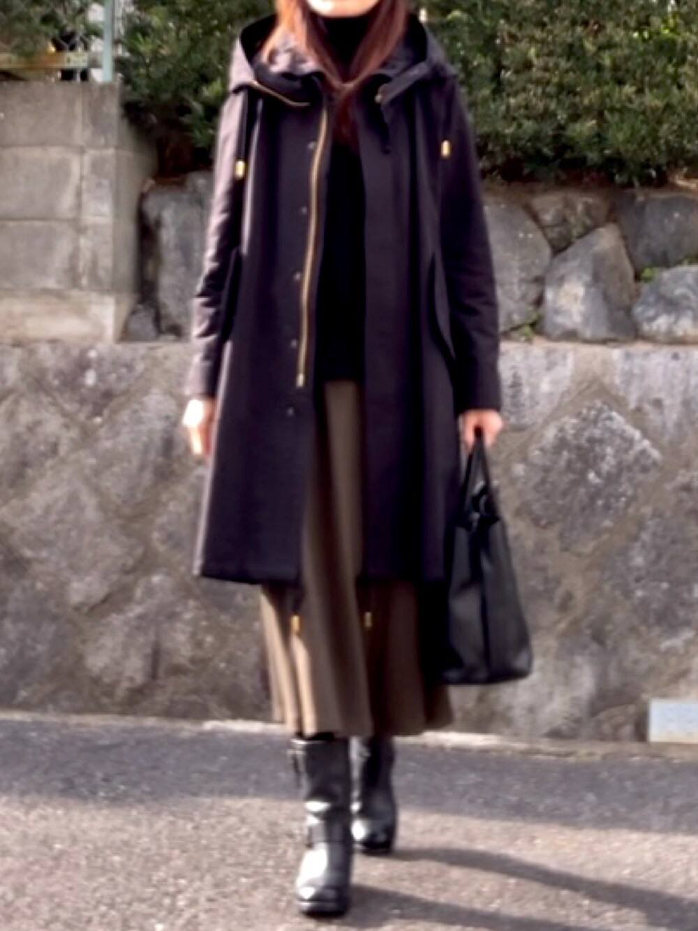 ブラック系のその他アウター、ブラック系のニット/セーター、ブラック系のハンドバッグを着用したレディースの冬コーディネートの2枚目の写真