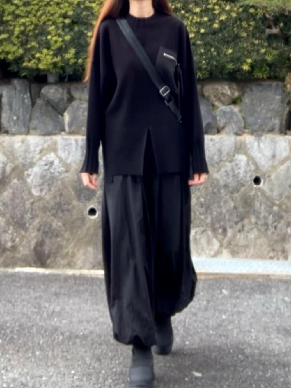 ブラック系のバッグ、ブラック系のニット/セーター、ブラック系のスカートを着用したレディースの冬コーディネートの4枚目の写真