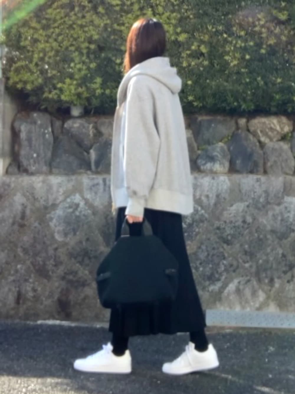 ブルー系のシャツ/ブラウス、グレー系のパーカー、ブラック系のスカートを着用したレディースの春コーディネートの2枚目の写真