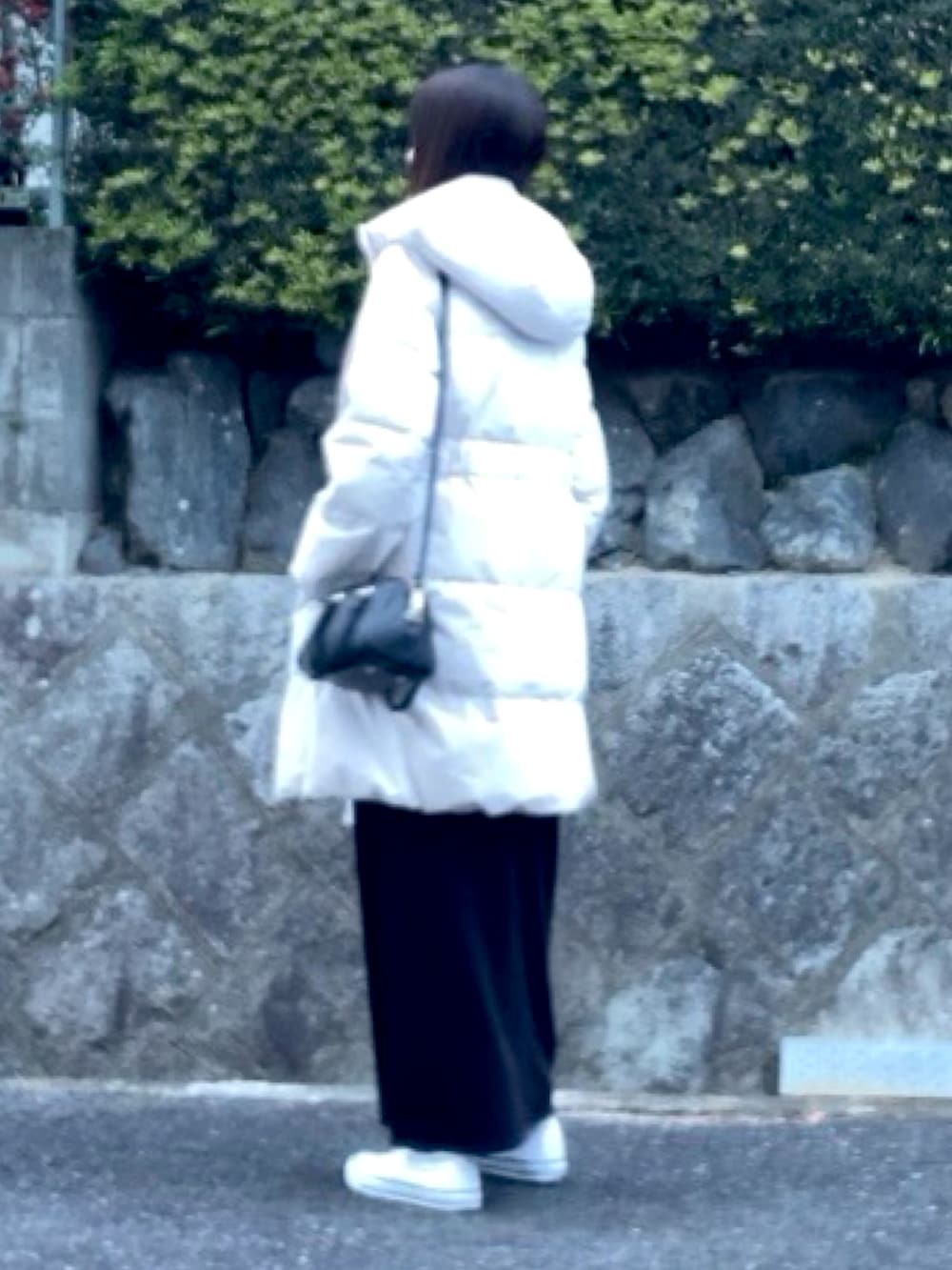 ベージュ系のダウンジャケット/コート、ブラック系のニット/セーター、ブラック系のスカートを着用したレディースの冬コーディネートの2枚目の写真