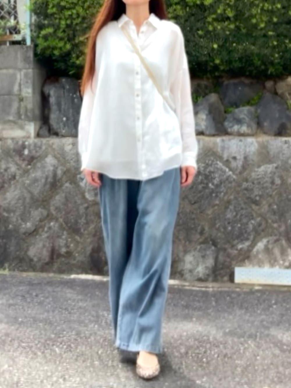 ブルー系のデニムパンツ、ホワイト系のシャツ/ブラウス、ゴールド系のトートバッグを着用したレディースの春コーディネートの3枚目の写真