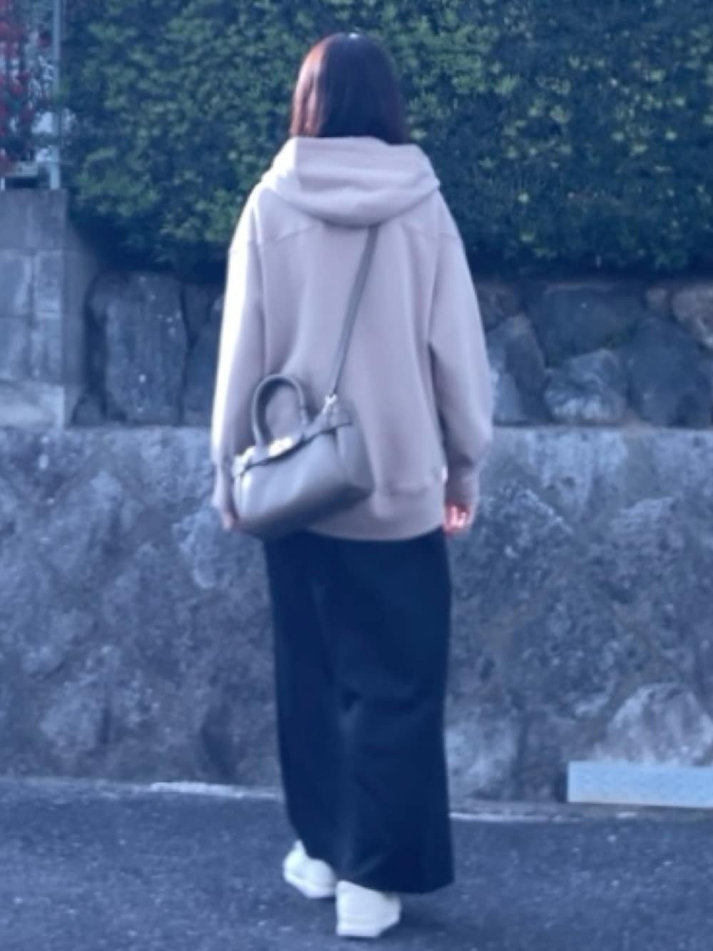 ベージュ系のパーカー、ブラック系のスカート、ベージュ系のハンドバッグを着用したレディースの冬コーディネートの4枚目の写真