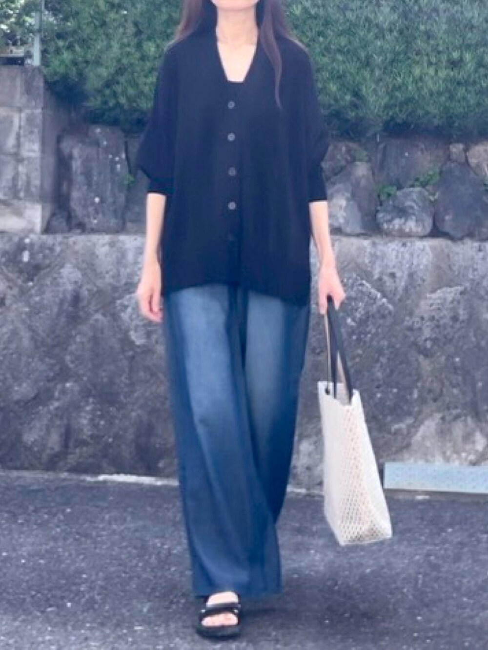 ブラック系のカーディガン/ボレロ、ブルー系のデニムパンツ、ホワイト系のトートバッグを着用したレディースの夏コーディネートの2枚目の写真