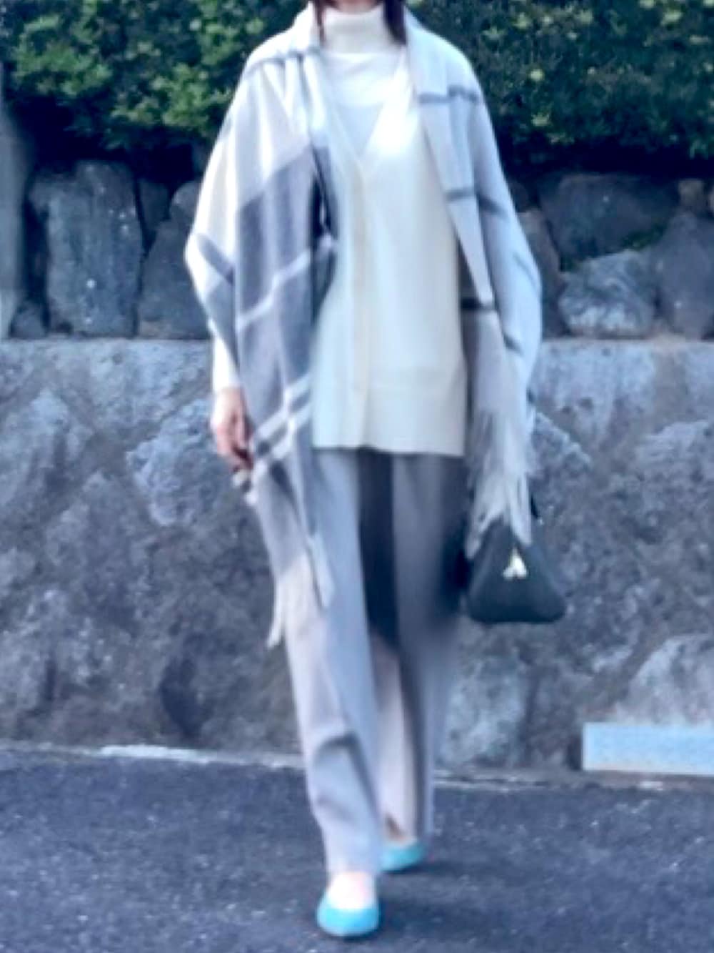 グレー系のボストンバッグ、ホワイト系のアンサンブル、ブルー系のパンプスを着用したレディースの冬コーディネートの3枚目の写真