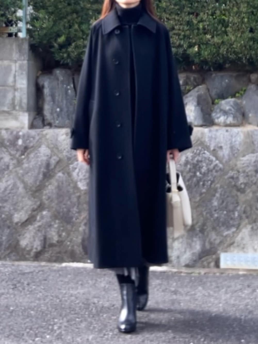 ブラック系のその他アウター、グレー系のスカート、ブラック系のブーツを着用したレディースの冬コーディネートの2枚目の写真