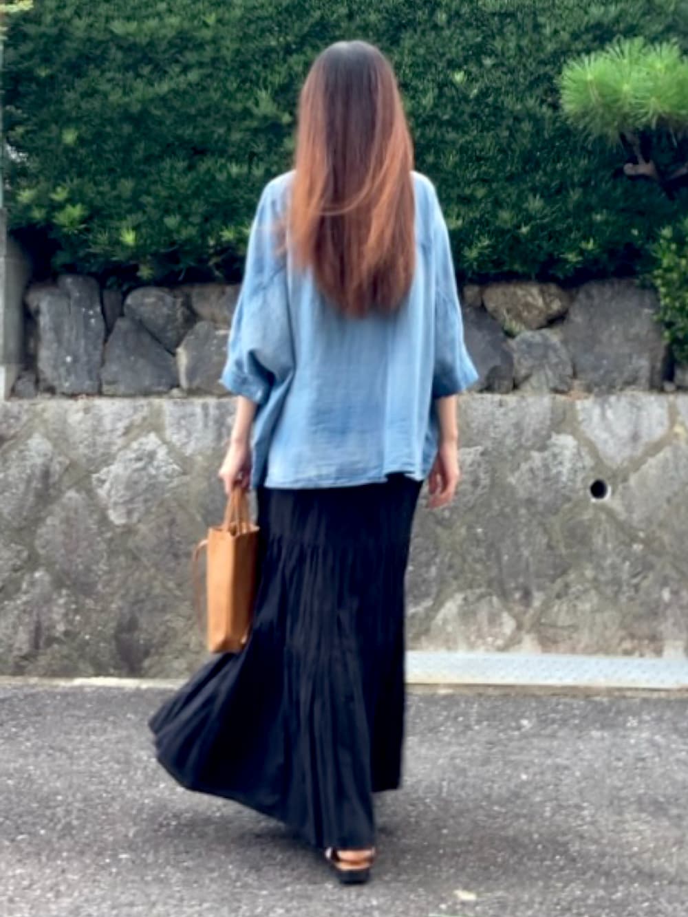 ブラック系のスカート、イエロー系のトートバッグ、ブラック系のサンダルを着用したレディースの夏コーディネートの3枚目の写真