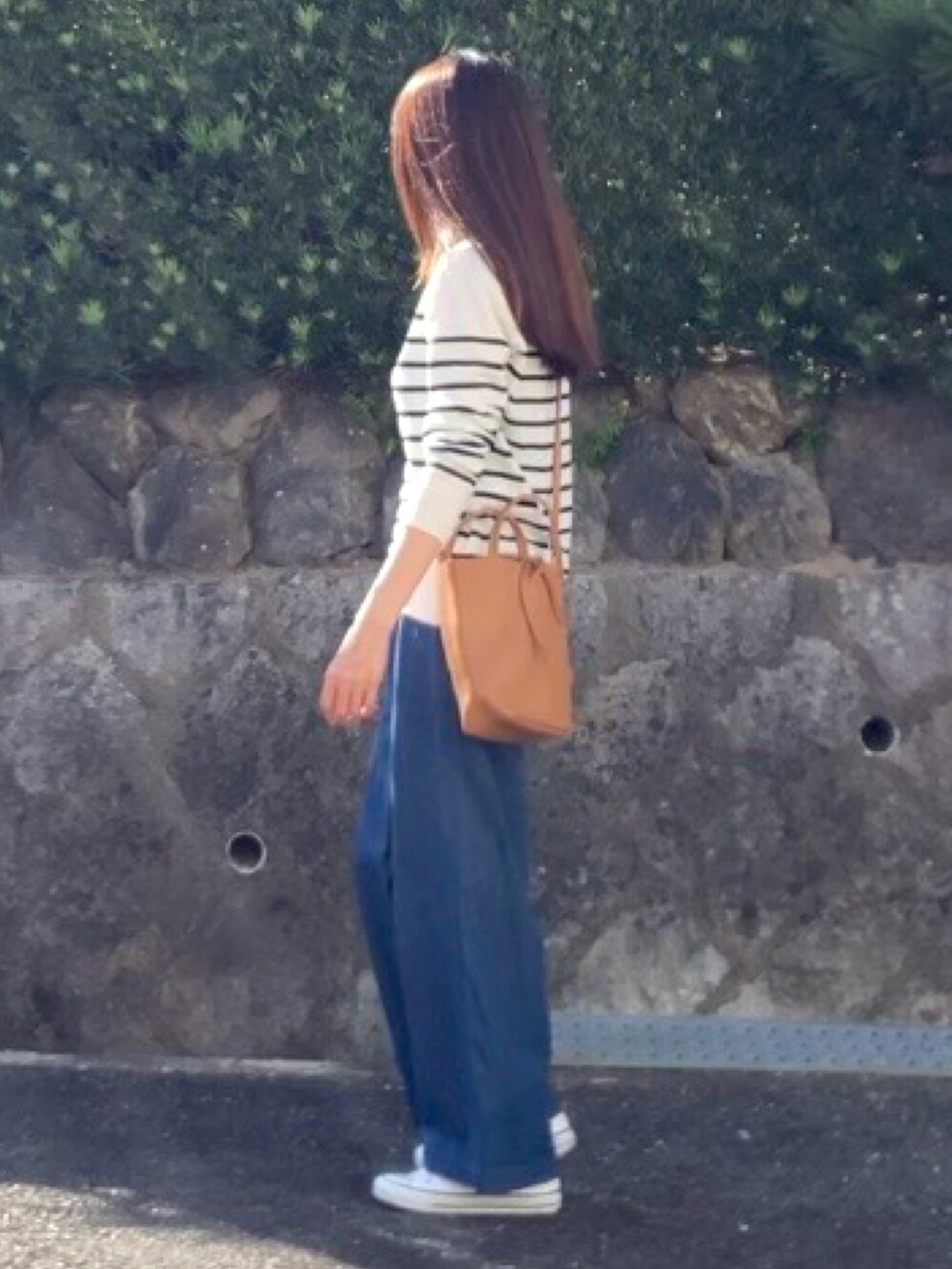 イエロー系のトートバッグ、ホワイト系のスニーカーを着用したレディースの秋コーディネートの2枚目の写真