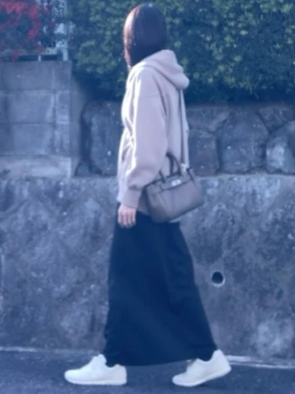 ベージュ系のパーカー、ブラック系のスカート、ベージュ系のハンドバッグを着用したレディースの冬コーディネートの3枚目の写真