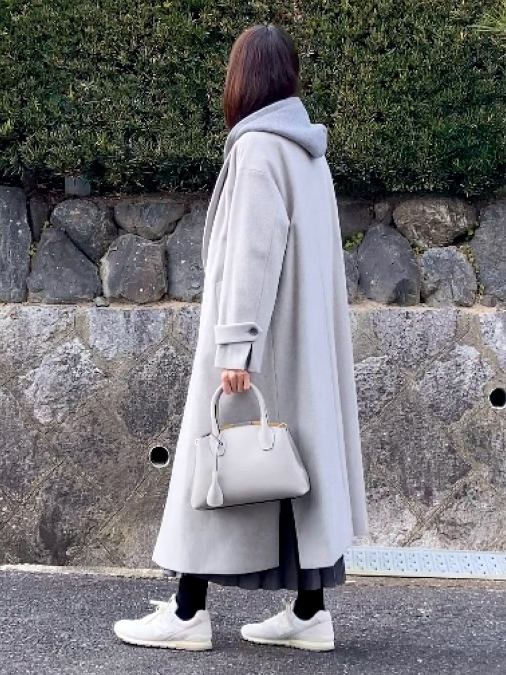 グレー系のパーカー、グレー系のニット/セーター、グレー系のスカートを着用したレディースの冬コーディネートの2枚目の写真