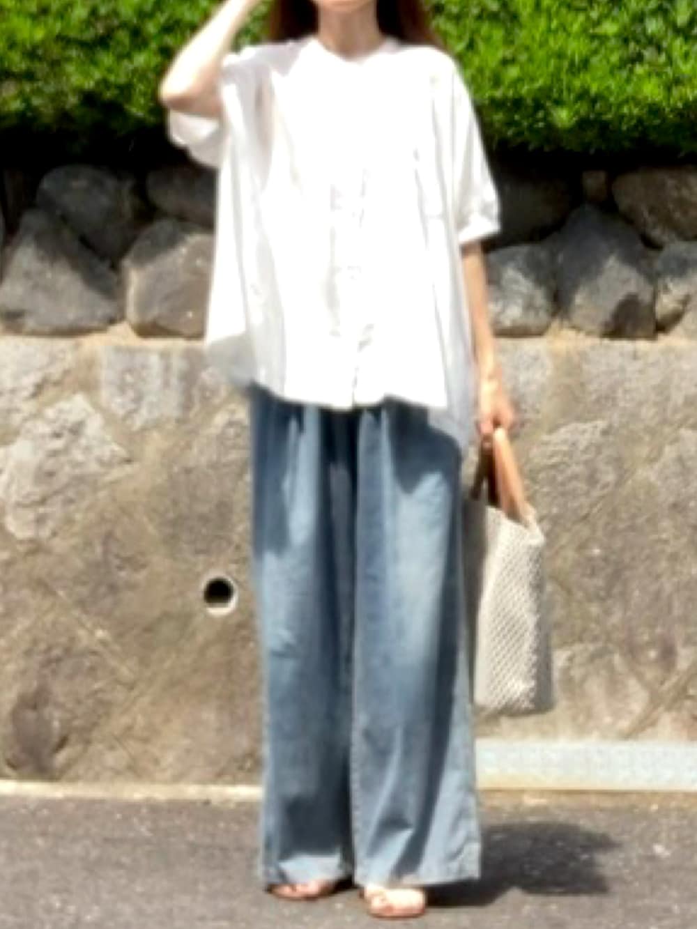 ブルー系のデニムパンツ、ホワイト系のシャツ/ブラウス、ベージュ系のバッグを着用したレディースの夏コーディネートの3枚目の写真