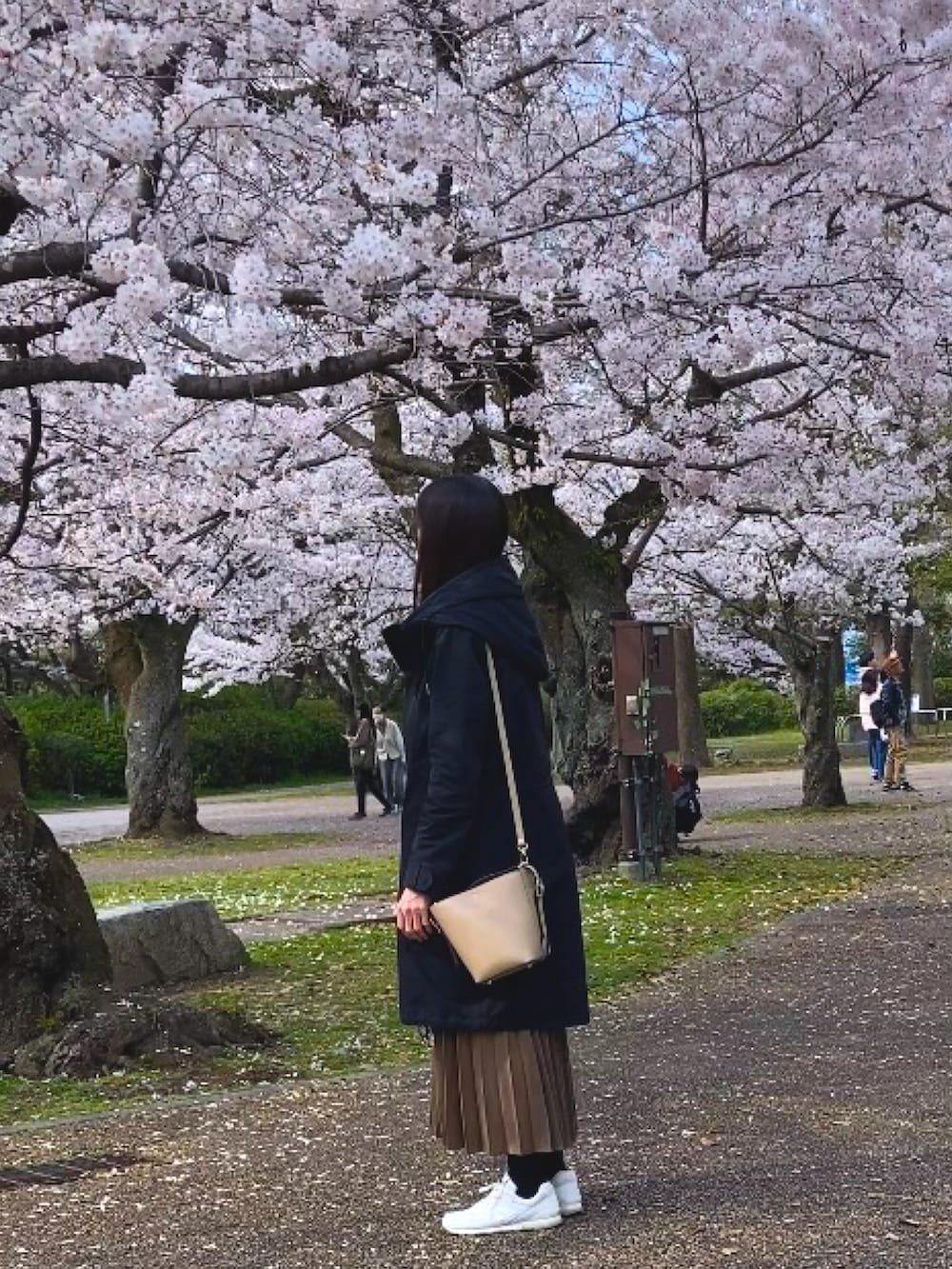 ブラック系のその他アウター、ベージュ系のトートバッグ、ブラック系のワンピースを着用したレディースの春コーディネートの2枚目の写真