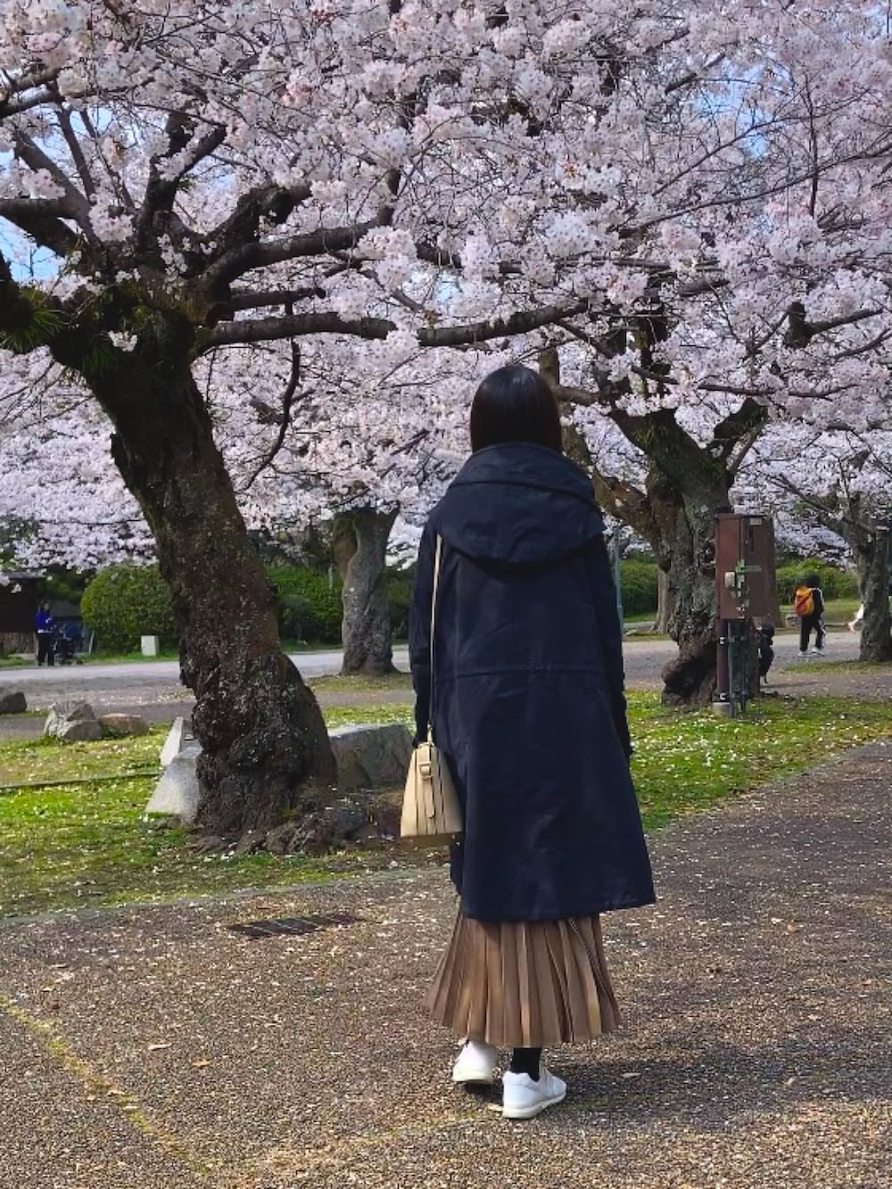 ブラック系のその他アウター、ベージュ系のトートバッグ、ブラック系のワンピースを着用したレディースの春コーディネートの3枚目の写真