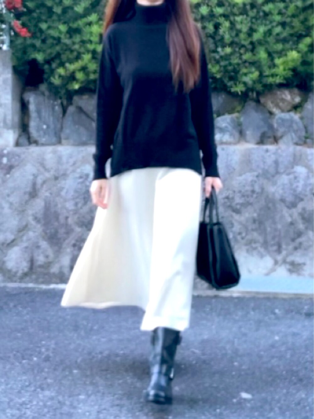 ブラック系のニット/セーター、ブラック系のトートバッグ、ブラック系のブーツを着用したレディースの秋コーディネートの2枚目の写真