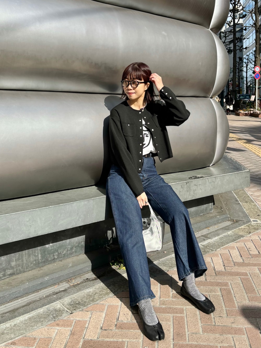 ブラック系のノーカラージャケット、その他のTシャツ/カットソー、ブルー系のデニムパンツを着用したレディースの冬コーディネートの2枚目の写真
