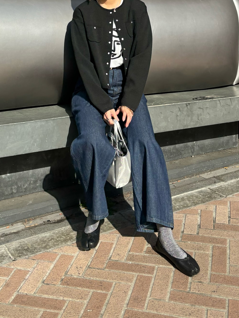 ブラック系のノーカラージャケット、その他のTシャツ/カットソー、ブルー系のデニムパンツを着用したレディースの冬コーディネートの3枚目の写真