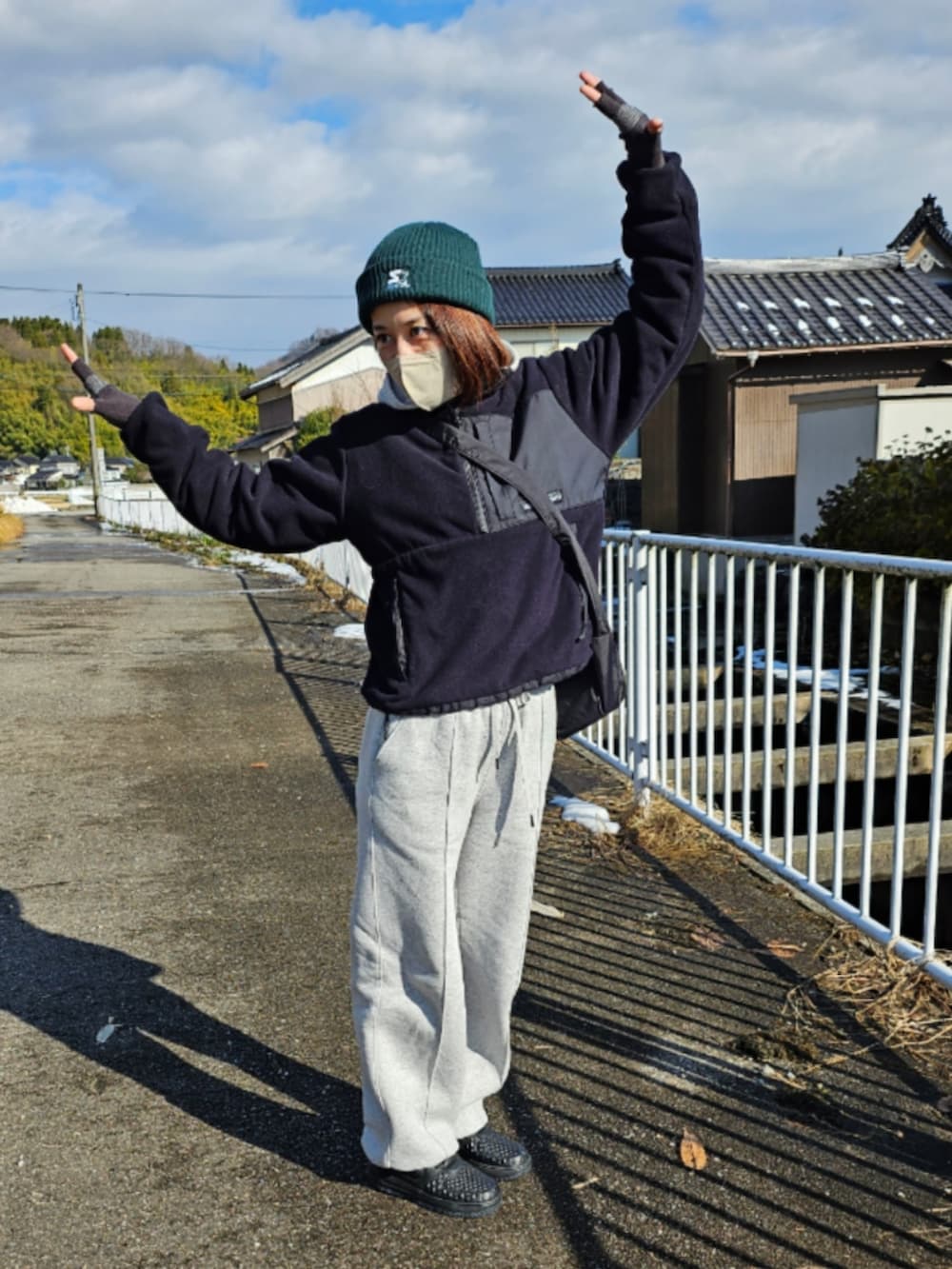 ブラック系のブルゾン、グレー系のスウェットパンツ、ブラック系のスニーカーを着用したレディースの冬コーディネートの2枚目の写真