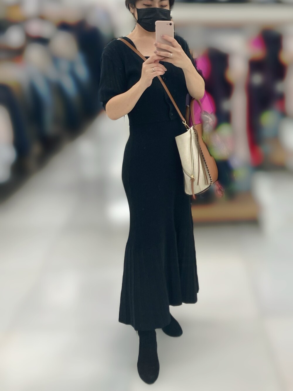 ブラック系のワンピース、ブラウン系のバッグ、ブラック系のブーツを着用したレディースの秋コーディネートの2枚目の写真