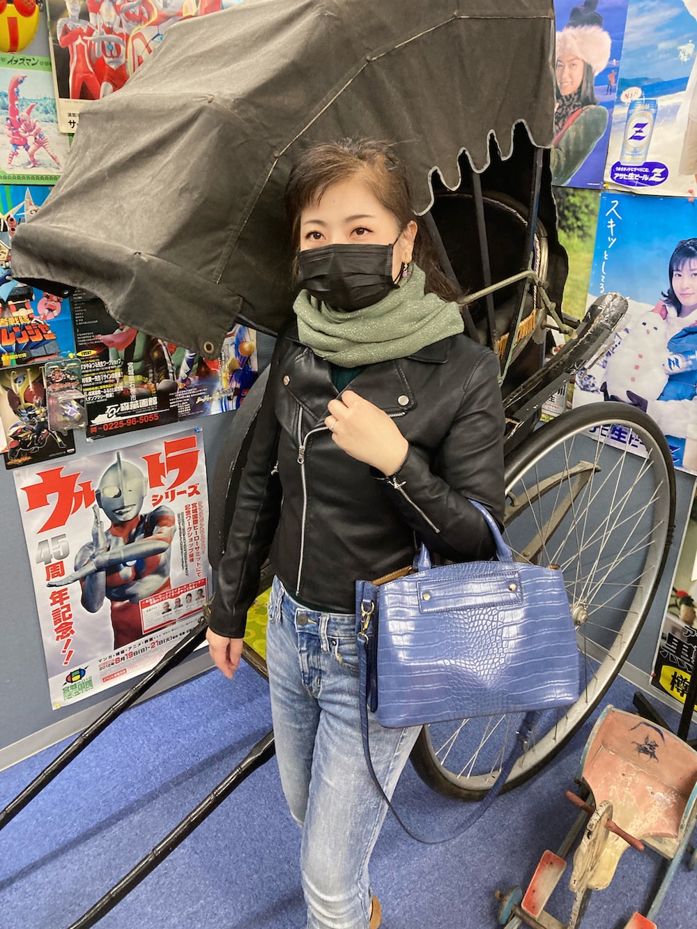 ブルー系のデニムパンツ、ブラック系のライダースジャケット、ブルー系のトートバッグを着用したレディースの春コーディネートの3枚目の写真