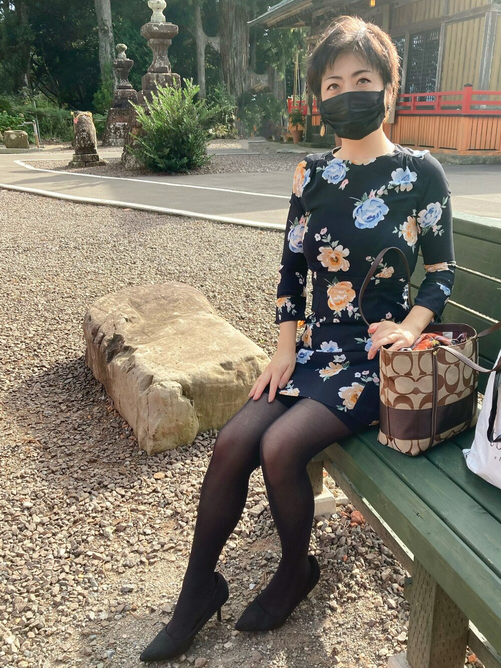 ブラック系のワンピース、ブラック系のパンプスを着用したレディースの秋コーディネートの2枚目の写真