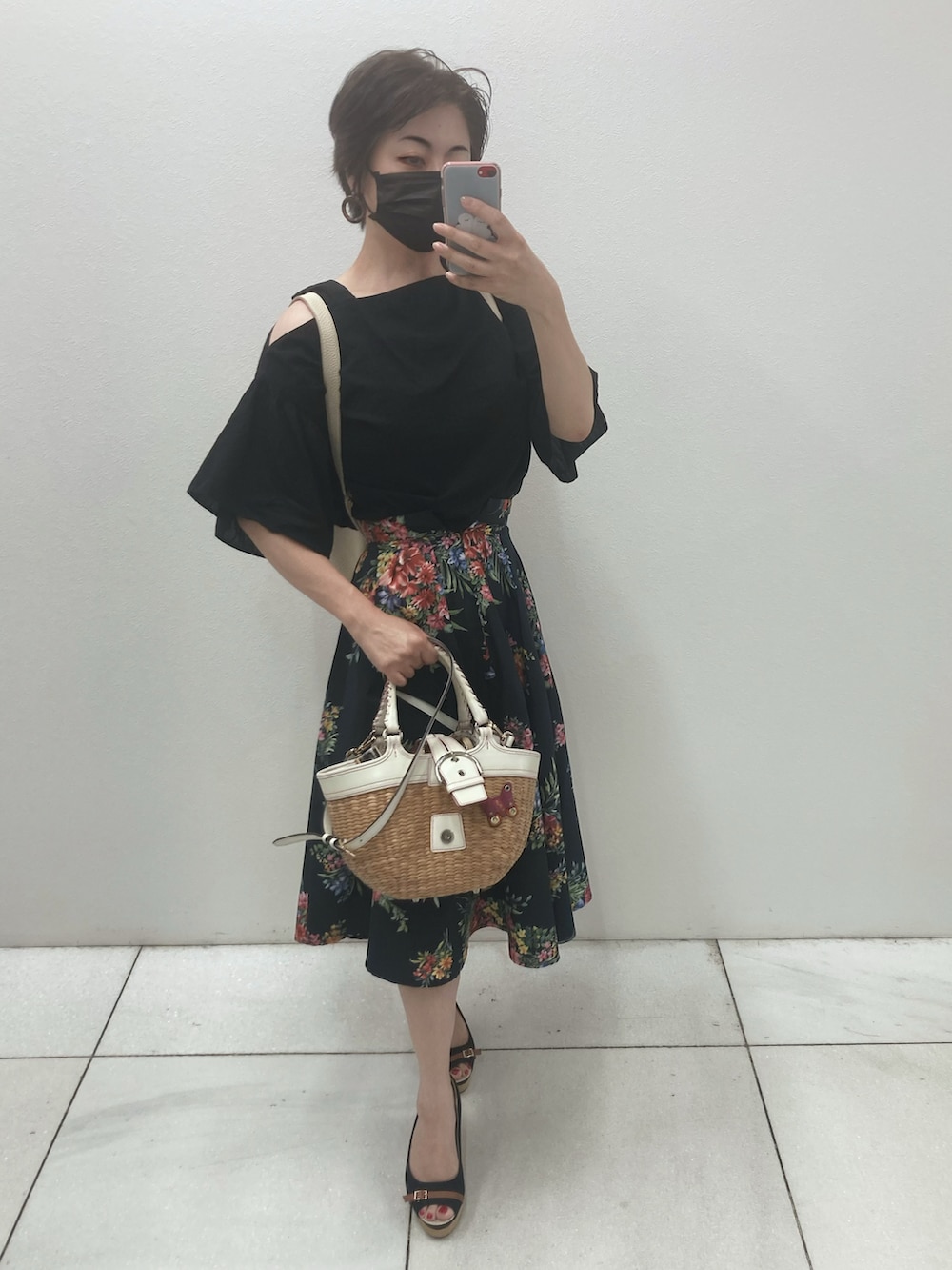 ブラック系のトップス、ブラック系のスカート、ベージュ系のかごバッグを着用したレディースの夏コーディネートの2枚目の写真