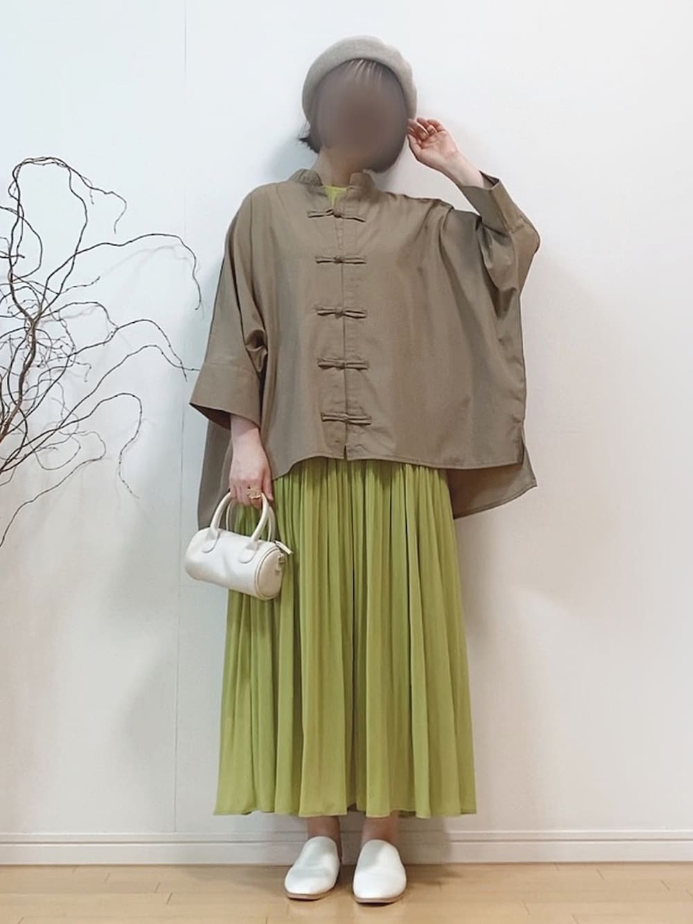 ブラウン系のシャツ/ブラウス、グリーン系のワンピース、ホワイト系のショルダーバッグを着用したレディースの春コーディネートの2枚目の写真