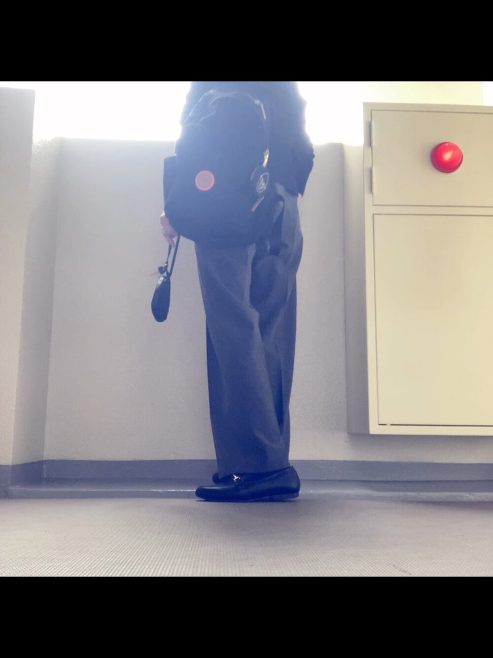 ブラック系のカーディガン/ボレロ、グレー系のパンツ、ブラック系のローファーを着用したレディースの秋コーディネートの3枚目の写真