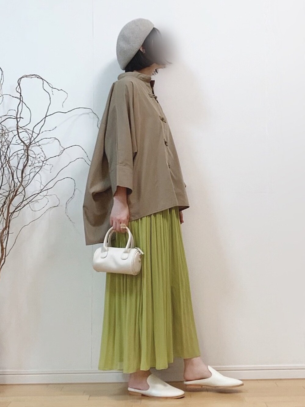 ブラウン系のシャツ/ブラウス、グリーン系のワンピース、ホワイト系のショルダーバッグを着用したレディースの春コーディネートの4枚目の写真