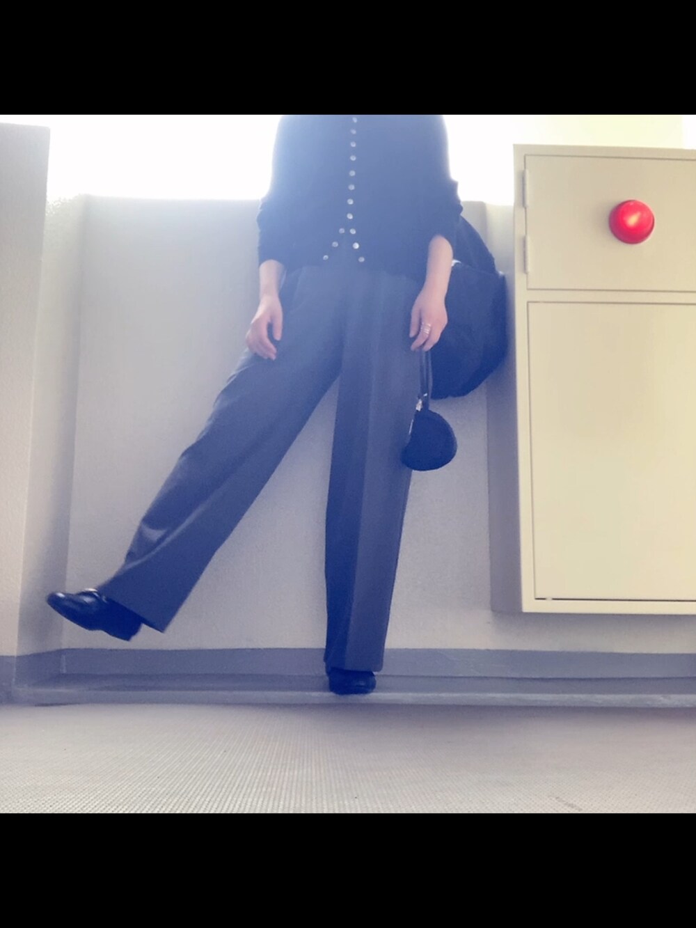 ブラック系のカーディガン/ボレロ、グレー系のパンツ、ブラック系のローファーを着用したレディースの秋コーディネートの2枚目の写真