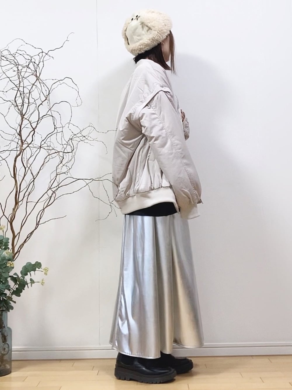 ホワイト系のMA-1、グレー系のニット/セーター、シルバー系のスカートを着用したレディースの冬コーディネートの2枚目の写真