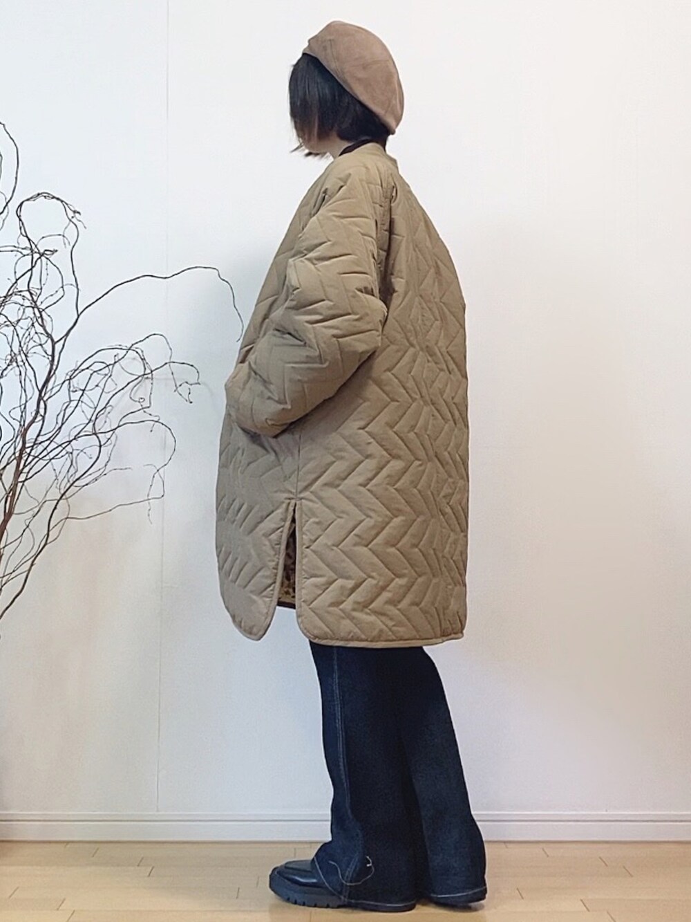 ブルー系のサロペット/オーバーオール、ベージュ系のダウンジャケット/コート、ブラック系のブーツを着用したレディースの冬コーディネートの3枚目の写真