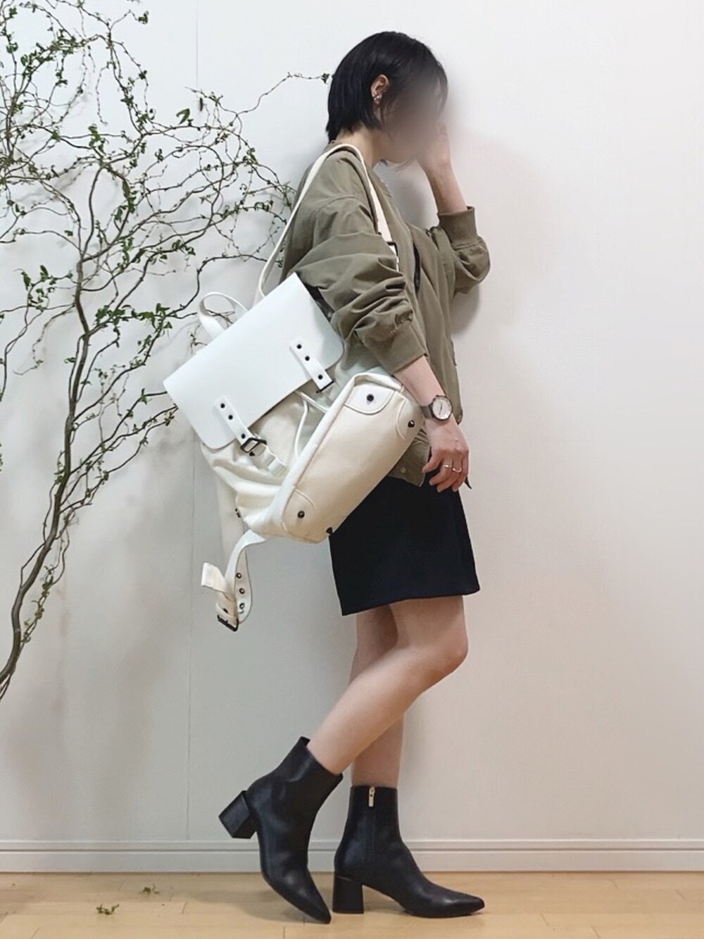 グリーン系のMA-1、ブラック系のブーツ、ホワイト系のバックパック/リュックを着用したレディースの春コーディネートの2枚目の写真
