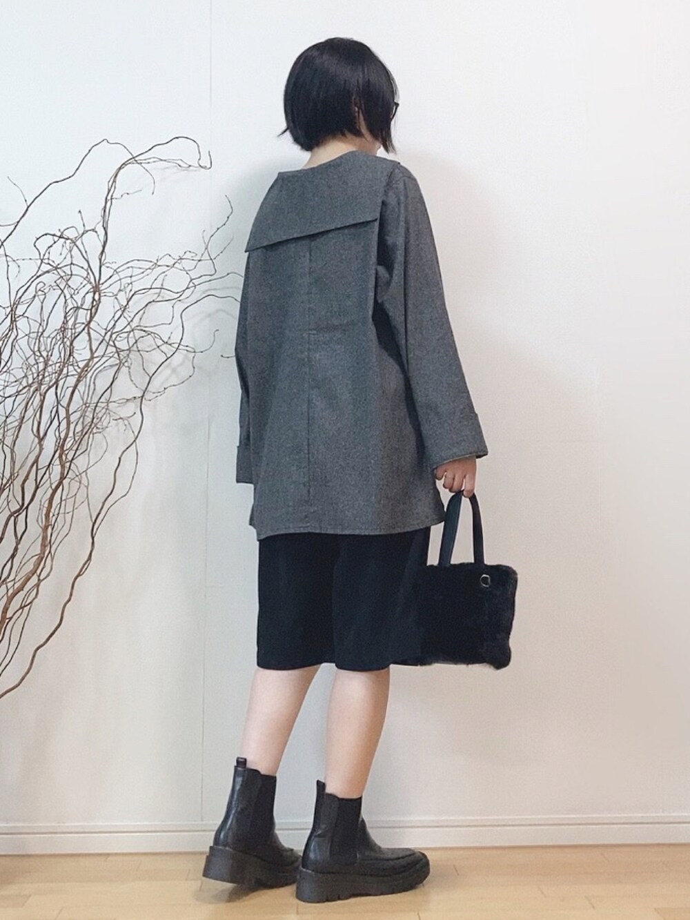 ブラック系のトップス、ブラック系のパンツ、ブラック系のブーツを着用したレディースの秋コーディネートの2枚目の写真