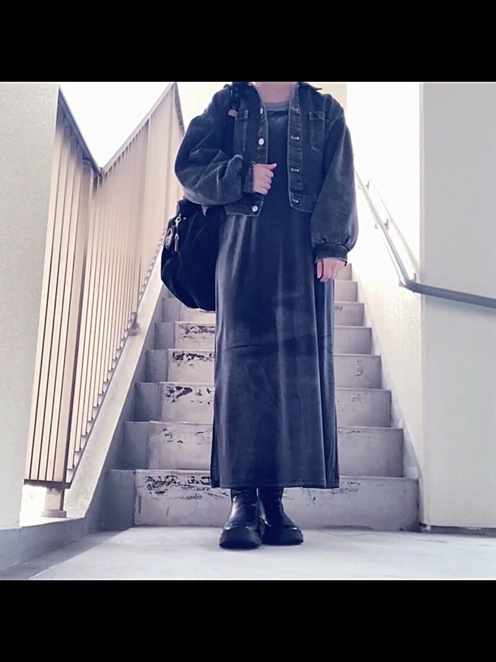 ブラック系のデニムジャケット、グレー系のワンピース/ドレス、ブラック系のバックパック/リュックを着用したレディースの秋コーディネートの2枚目の写真