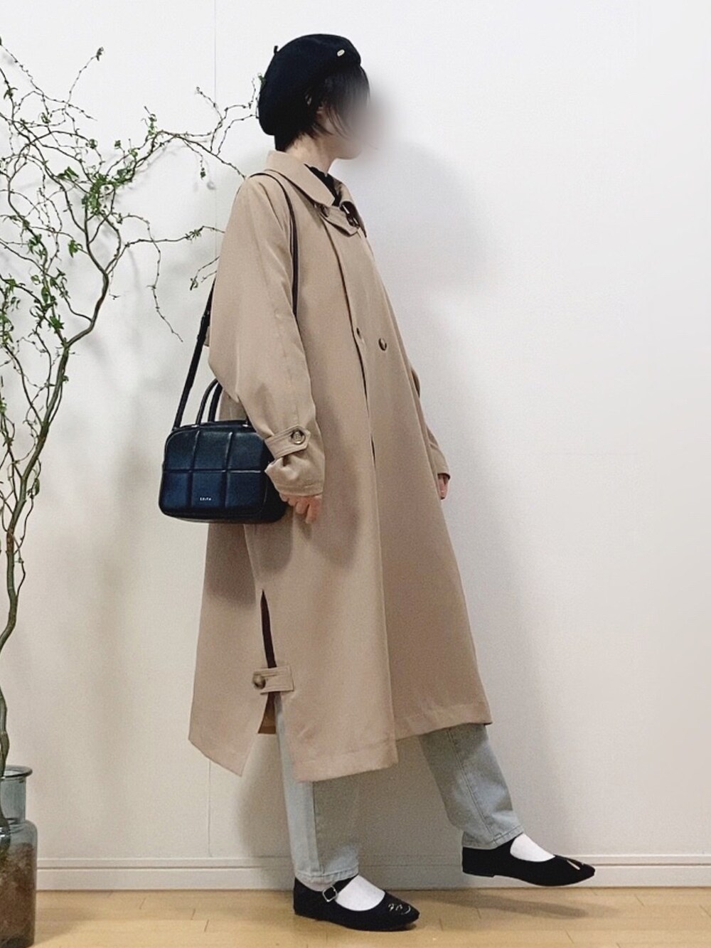 ベージュ系のトレンチコート、ブラック系のTシャツ/カットソー、ブルー系のデニムパンツを着用したレディースの春コーディネートの3枚目の写真