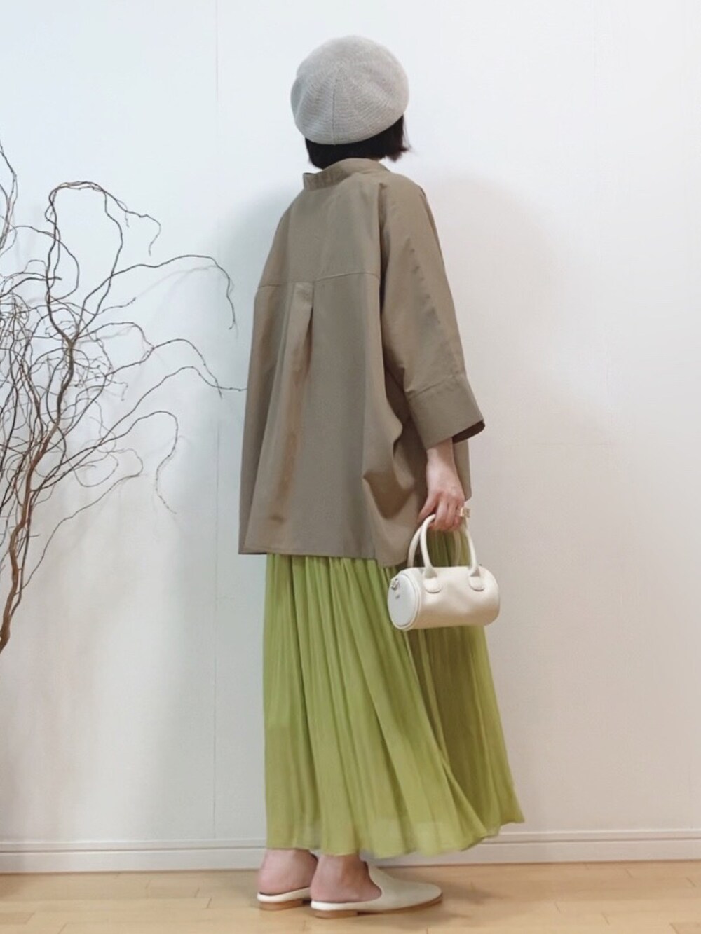 ブラウン系のシャツ/ブラウス、グリーン系のワンピース、ホワイト系のショルダーバッグを着用したレディースの春コーディネートの5枚目の写真