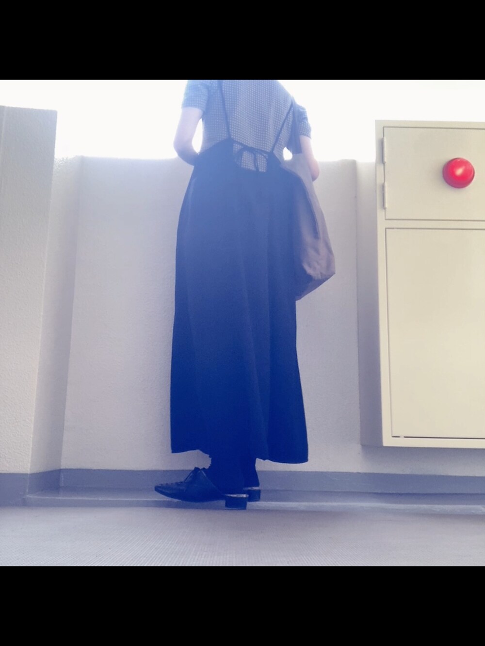 ブラック系のワンピース/ドレス、ブラウン系のトートバッグ、ブラック系のサンダルを着用したレディースの秋コーディネートの3枚目の写真