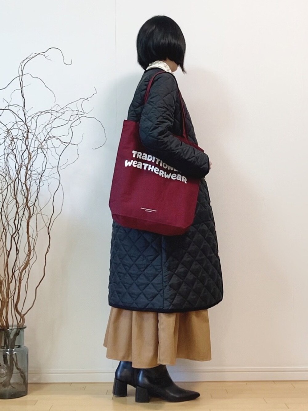 ブラック系のその他アウター、レッド系のトートバッグ、ベージュ系のワンピースを着用したレディースの冬コーディネートの3枚目の写真