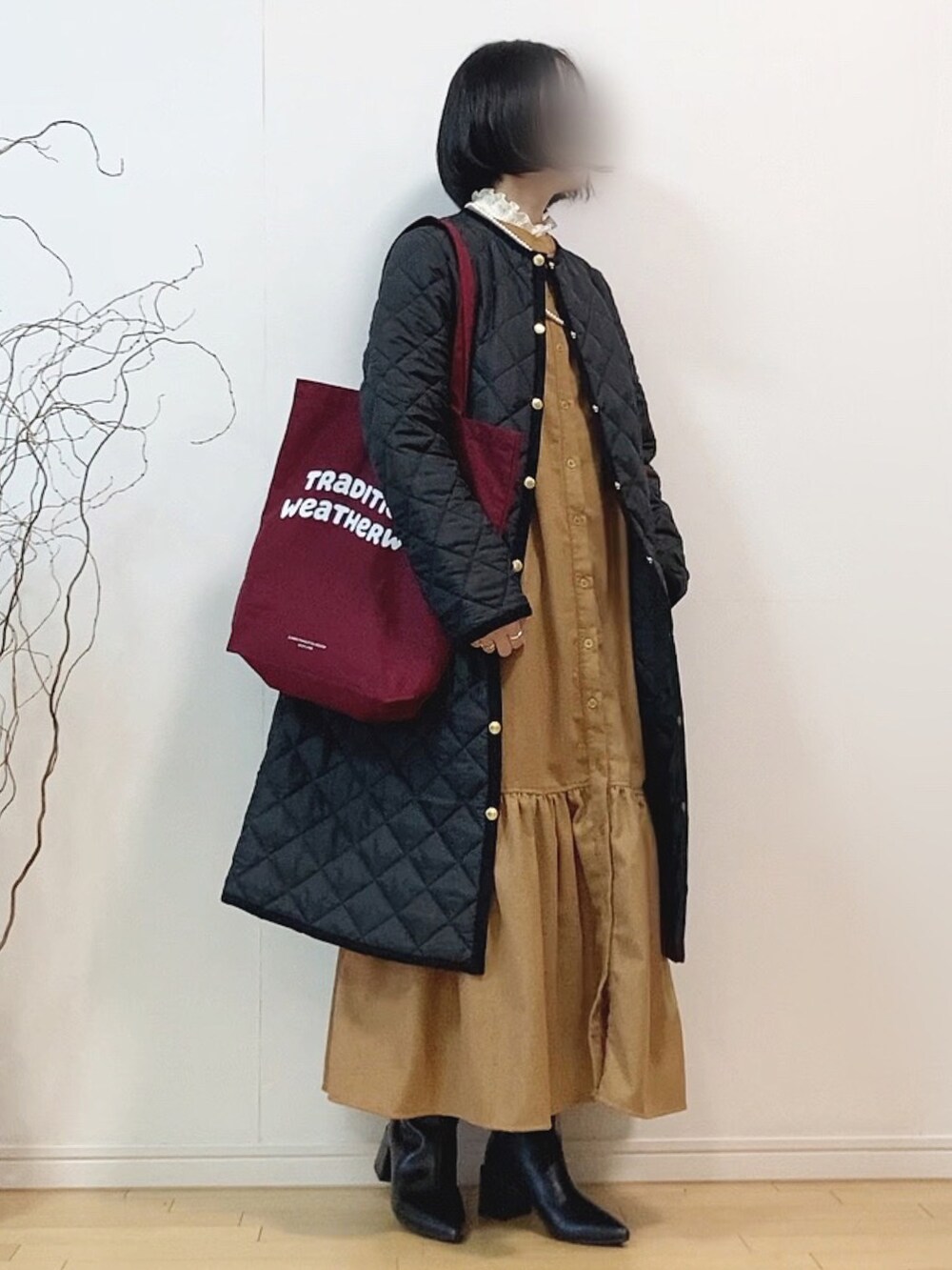 ブラック系のその他アウター、レッド系のトートバッグ、ベージュ系のワンピースを着用したレディースの冬コーディネートの2枚目の写真