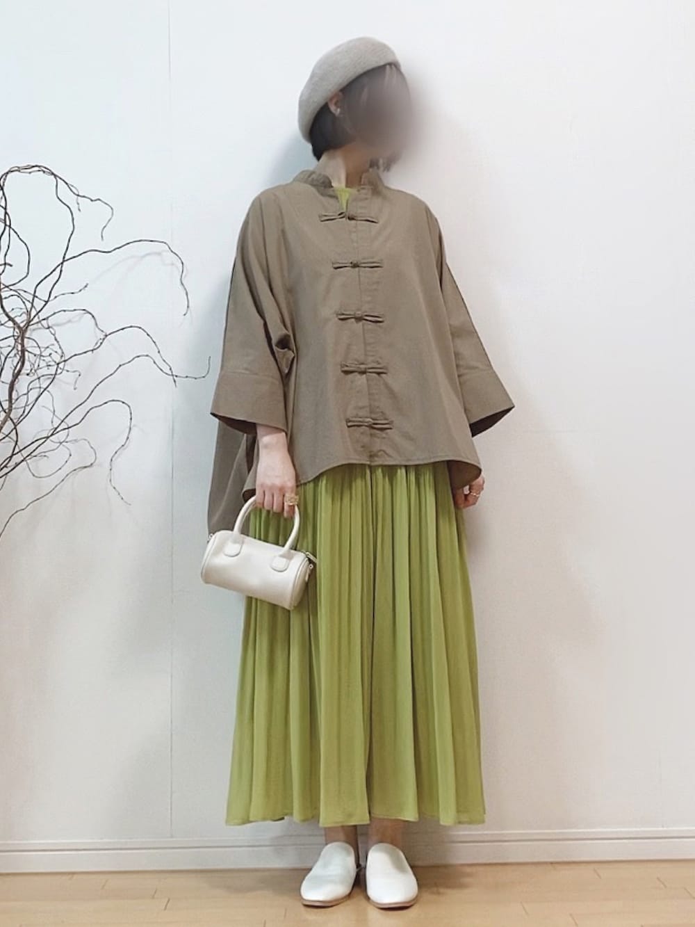 ブラウン系のシャツ/ブラウス、グリーン系のワンピース、ホワイト系のショルダーバッグを着用したレディースの春コーディネートの3枚目の写真